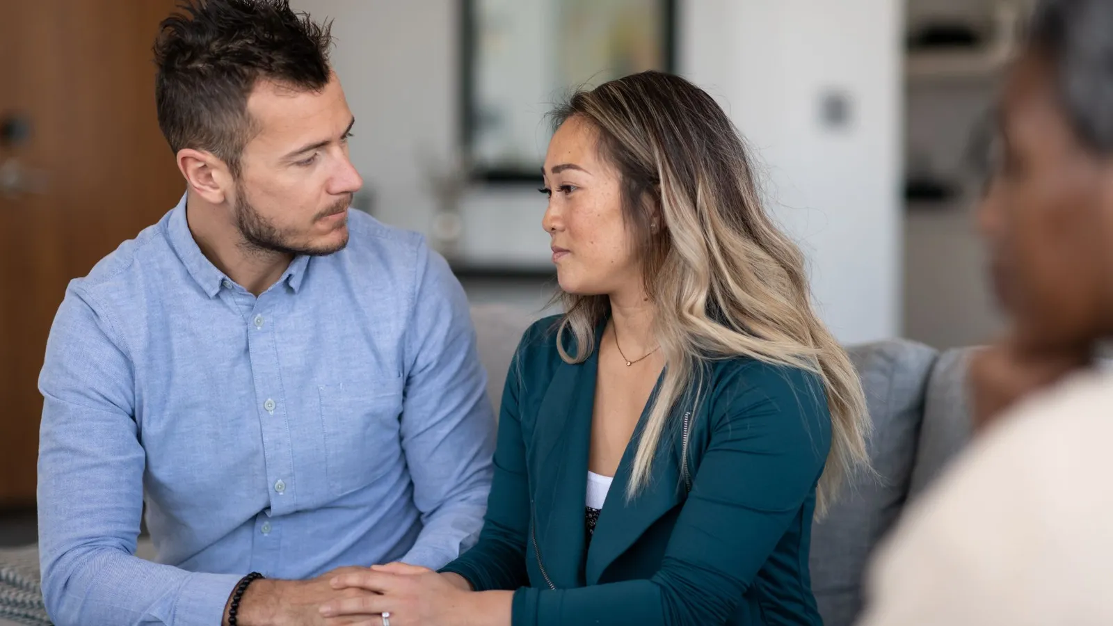 Couple assis côte à côte face à un agent lors de l'entretien de naturalisation par mariage