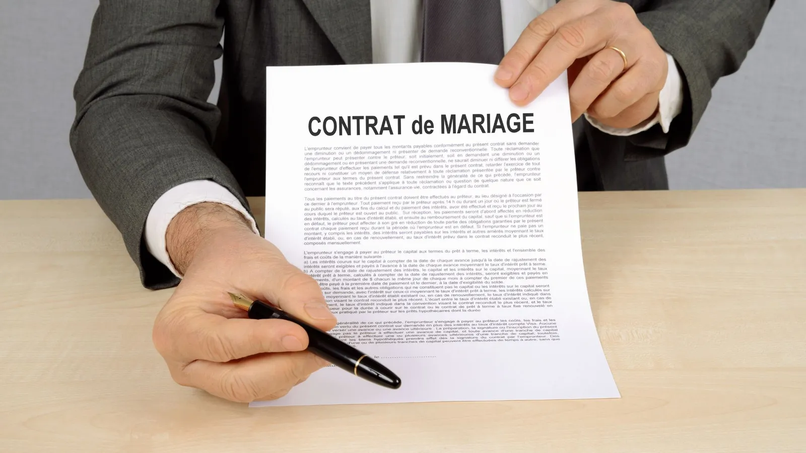 Homme en costume tendant un document et un stylo, image du recours écrit contre un refus de naturalisation par mariage